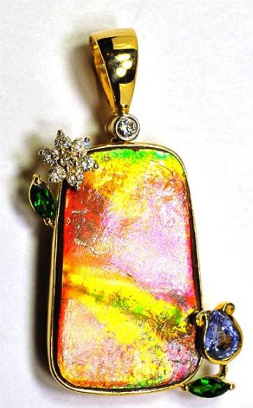 jewelry set in yellow gold with ammolite in center, and flowers made of diamonds and gems