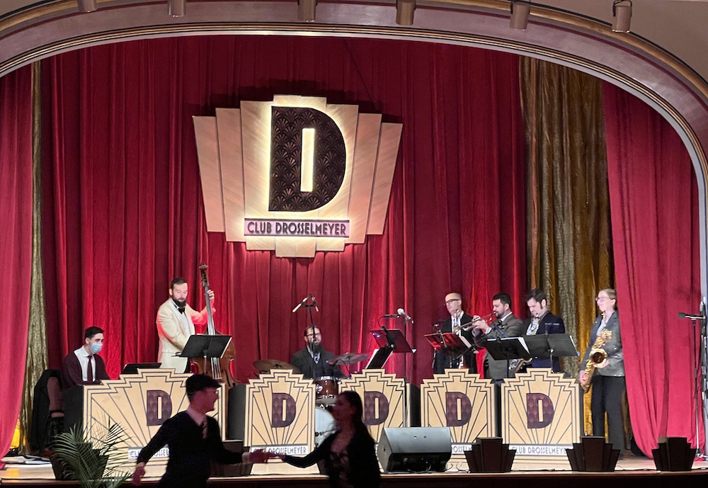 The Drosselmeyer big band on the beautiful guilded stage with a couple dancing in front of them.