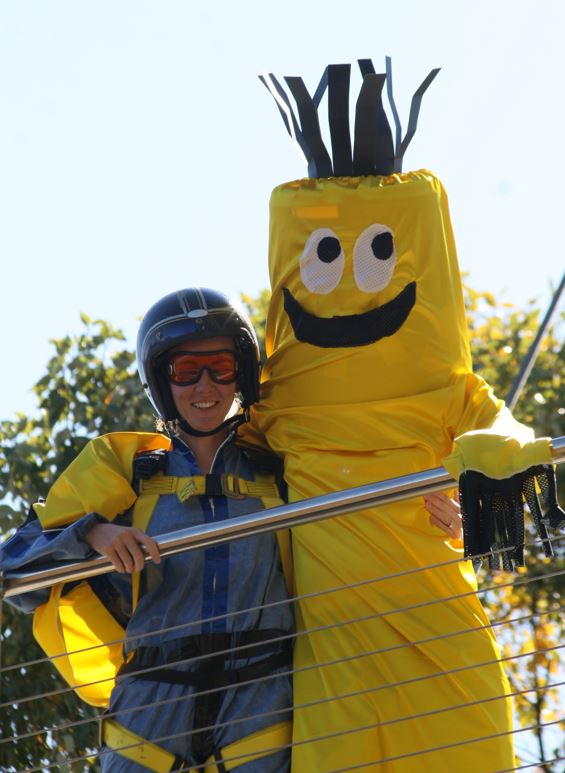 woman in blue skydiving jumpsuit and helmet posed with man in yellow air dancer costume
