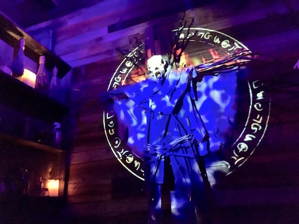 In-game: an effigy hanging from the wall with fire projected onto it.