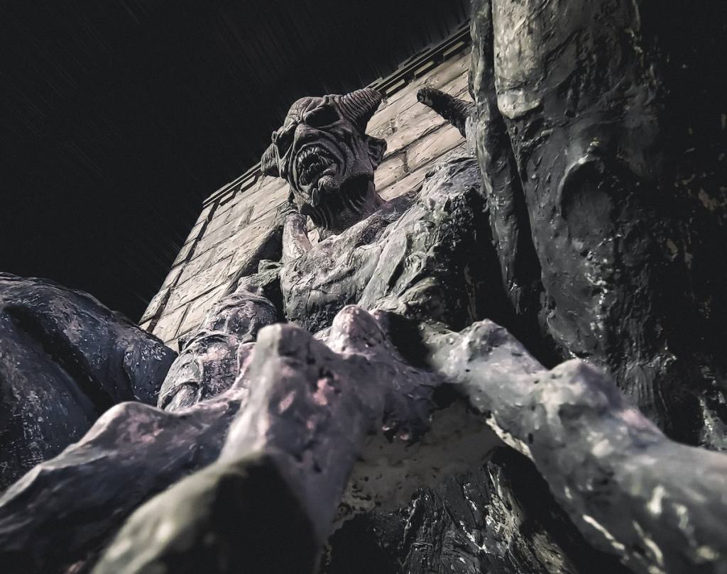 Stoney protrusions on the side of a cathedral wall with a demon's head.