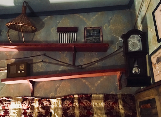 A strange rube goldeberg machine mounted to the wall.