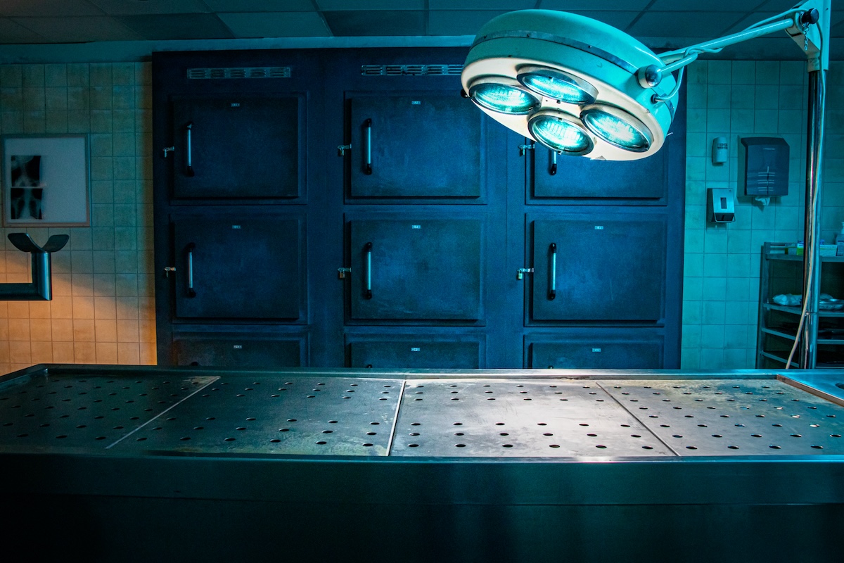 An autopsy table in a lab. Freezers are in the background.