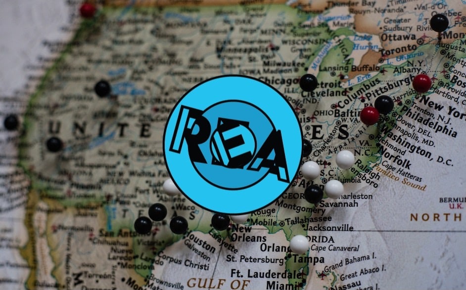 REA logo with a photo of a pinned map of the USA in the background. 