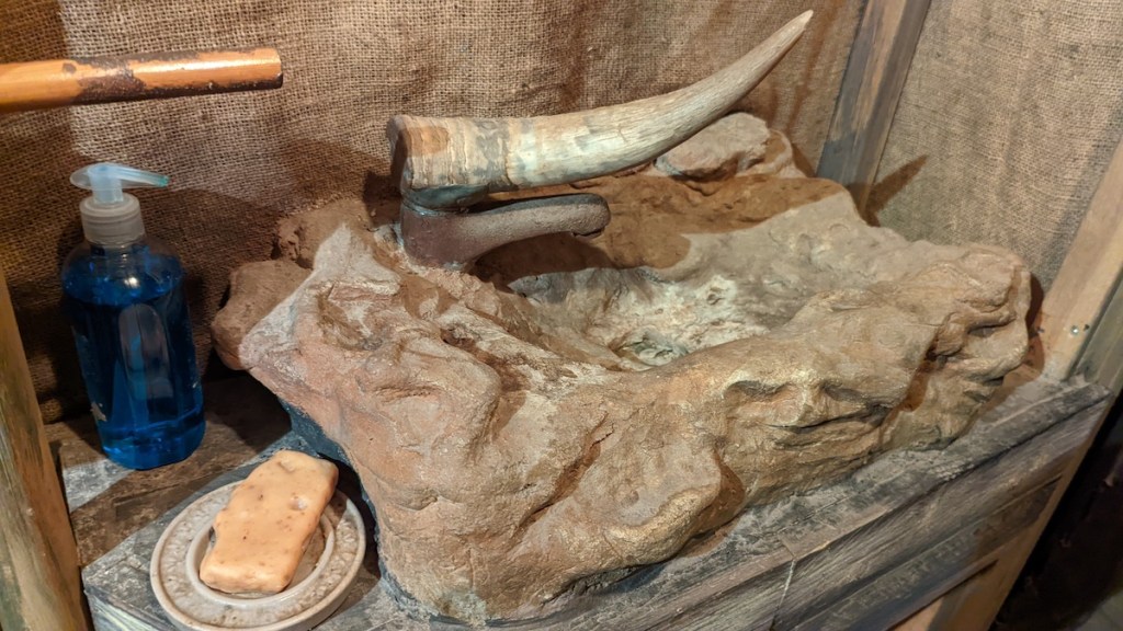 A horn beside a bottle of liquid soap at an archeological dig.