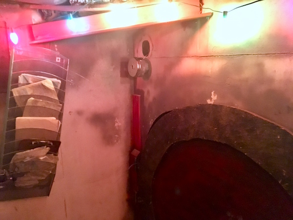 In-game: An interior of the bunker. A wallhanging holds paperwork, the bunker looks rundown.
