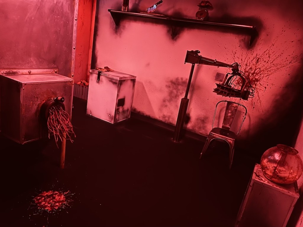 A room lit red and filled with torture devices