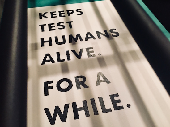 In-game: A sign that reads, "Keeps test humans alive. For a while."
