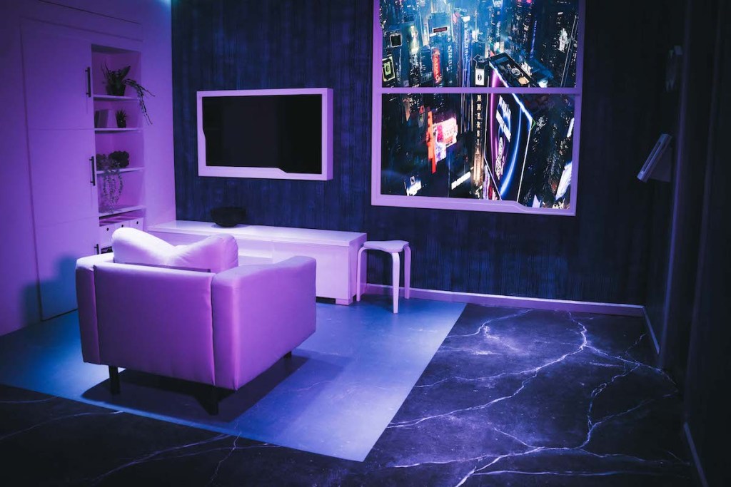 A livingroom in a cyberpunk apartment with a large window overlooking a futuristic cityscape.