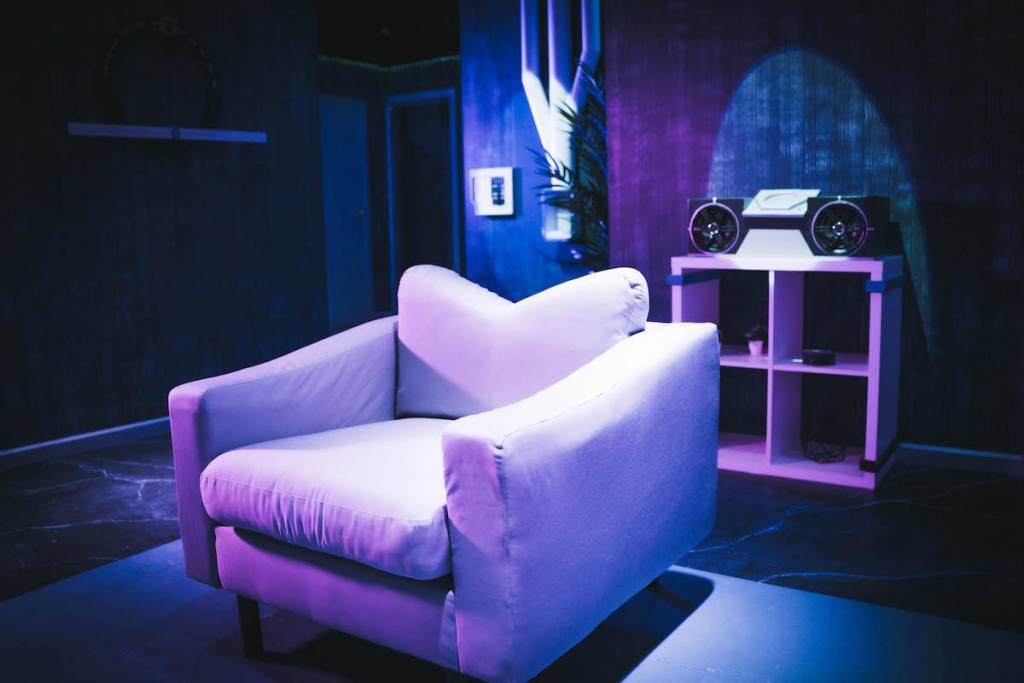 A large, comfortable white chair in a cyberpunk apartment