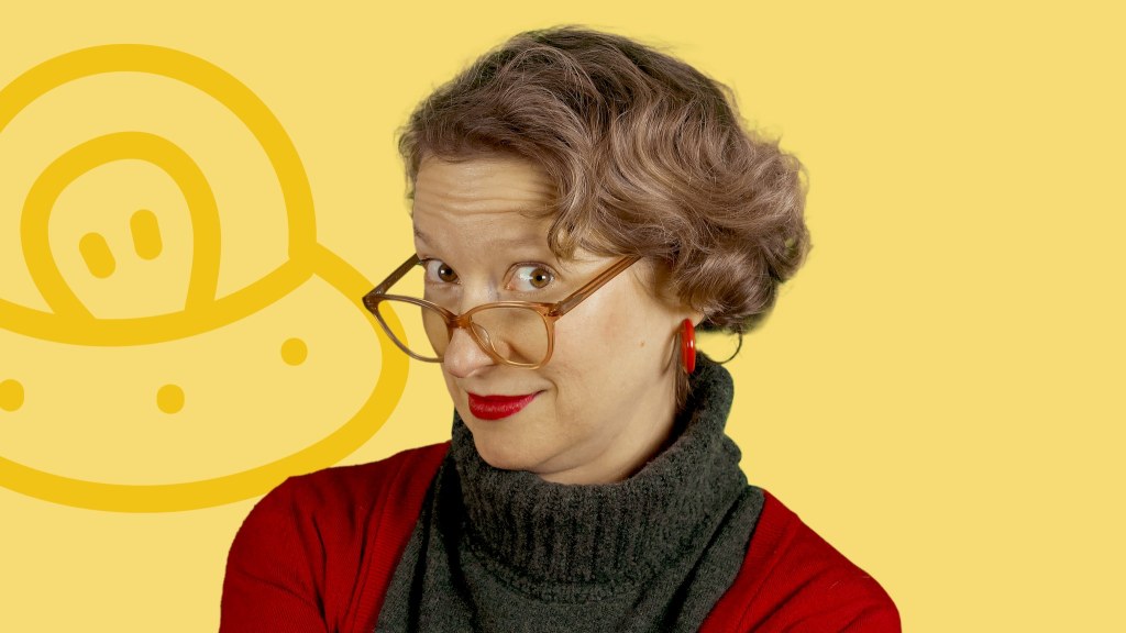 woman with short wavy blondish brown hair and glasses. She is wearing a grey turtleneck sweater and a red cardigan. The background is bright yellow with a cartoon UFO