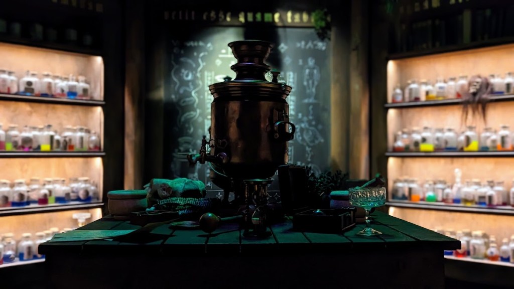 An elaborate pot with a spigot sits on a table in an alchemist's lab.