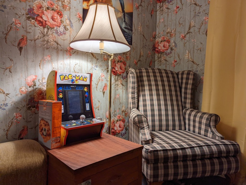 An old living room with a small packman arcade machine.