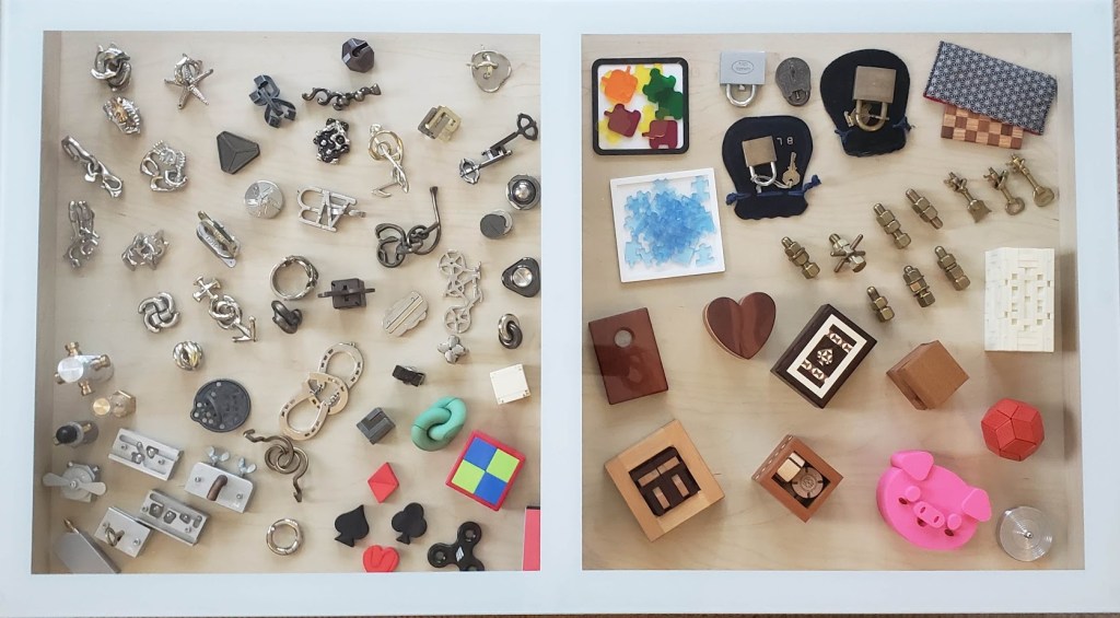 layout of almost 100 metal and acrylic mechanical puzzles