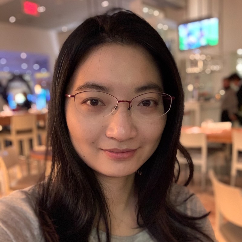 asian woman with glasses smiling