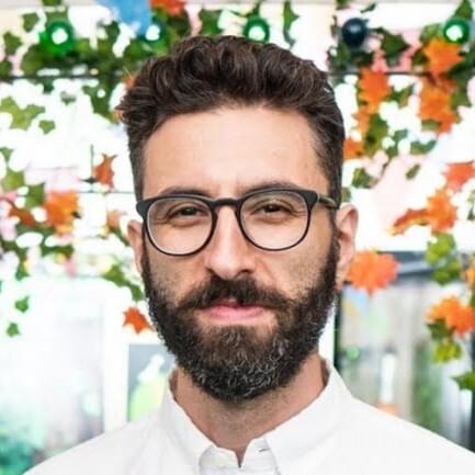 man brown hair and medium length beard with glasses in white button down shirt